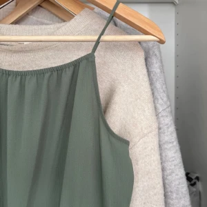 Grön jumpsuit med smala axelband - Snygg ljusgrön jumpsuit med smala axelband och resår i midjan. Modellen har en öppen detalj i ryggen och vida ben. Perfekt för dig som gillar en avslappnad men trendig stil. Storlek 158 från H&M💞