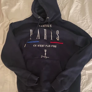 Mörkblå hoodie från Santigue med Paris-tryck - Säljer denna jättefina huvtröja som jag fyndade på myrorna förra året! Säljer den då den inte kommer till använding och har inte använt så mycket! Nypris:runt 500! Tröjan är man storlek men passar unisex! Storlek S, inge Defekter