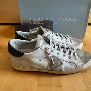 Vita sneakers från Philippe Model - Säljer ett par Philippe modell i en populär vit svart färg. Skorna är såklart autentiskta och alla tillbehör som du ser på bilderna följer med.       Skorna är storlek 40 Men passar också 41 då dem är snörade rätt så löst. Nypris ca 3000kr.         Pris är inte hugget, skriv om du undrar något 🙌
