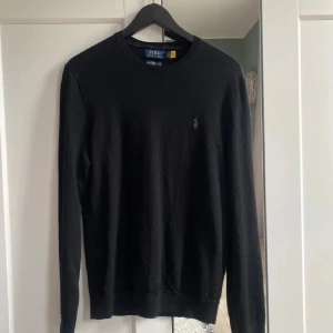  Ralph Lauren stickad tröja  - Säljer en svart långärmad tröja från Polo Ralph Lauren i slim fit-modell. Skicka 10/10 inga defekter. Modellen är 180cm lång men passar från 170 - 180. Ny priss 1200kr , mitt pris 450. Tveka inte om frågan ! Obs priset kan bara diskuteras vid snabb affär !
