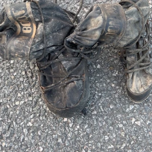 Svarta Moon Boots - Säljer ett par klassiska svarta Moon Boots med snörning och rund tå. Perfekta för kalla dagar och vinteraktiviteter. Tjock sula och hög modell som håller fötterna varma. Ikonisk logga upptill.