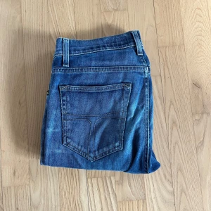 Blå jeansbyxor Från tiger of sweden - Säljer ett par klassiska blå jeans med raka ben från Tiger of Sweden.  Jeansen har normal passform Perfekta för en avslappnad stil och passar till det mesta.