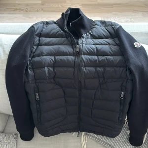 Svart cardigan från Moncler - Säljer en svart cardigan från Moncler med quiltad framsida och ärmar i stickad bomull. Säljer för att den inte passar lika bra längre jätte bra skick, går även att skanna märket för att komma till hemsidan. Tagg finns men inte på.👍🏼.                        Pris går att förhandlas lite.