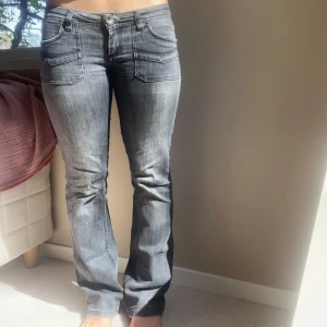 Grå bootcut jeans med låg midja  - Snygga grå lågmidjade jeans med bootcut-passform och coola fickdetaljer fram och bak. Skulle säga att de är ganska perfekta i längden på mig som är 164 💕 (finns lite slitage men inget som syns och lätt att fixa)