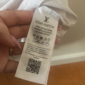 Vit t-shirt från Louis med broderad logga - Vit t-shirt från Louis  100% bomull med broderad svart logga på bröstet. Klassisk passform och korta ärmar. Perfekt för dig som gillar stilrena och exklusiva plagg.