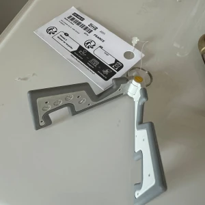Grå och vit vikbar mobilhållare från IKEA - Säljer en smidig och vikbar mobilhållare i grått och vitt från IKEA. Perfekt för att ställa mobilen både liggande och stående. Liten och lätt att ta med sig, passar till de flesta smartphones.