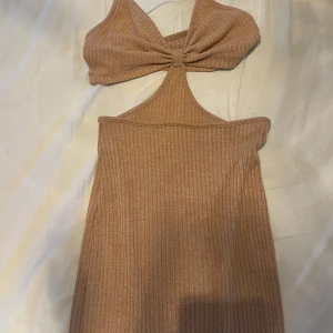 SHEIN Beige ribbad klänning - Trendig beige ribbad klänning med snygg rosettdetalj framtill och cut out vid midjan. Klänningen är ärmlös och framhäver figuren. Mellan mig o köpare kan det skickas bild på hur klänning ser ut på👍