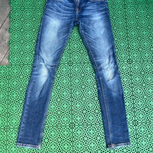 Blå skinny jeans från Nudie Jeans - Säljer ett par sköna nudie jeans i mörkblå färg. Skönt tvänting och slitningar. Om du vill ha mer bilder eller annat skriv. Storlek 27/32. Priset är inte spikat