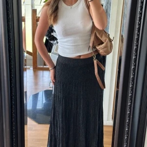 Silver glittrig stickad svart maxi skirt/kjol S stockholmsstil - Så snygg svart stickad kjol som är väldigt glittrig i färgen silver! Så snyggt fall och kjolen är även lite plisserad. Storlek S och du kan välja o ha den midwaist eller lowwaist. Knappt använd och i fint skick, så stockholmsstil och perfekt till sommaren👯‍♀️jag köpte den för ca 700kr för massa år sen! (Jag är 176cm lång)