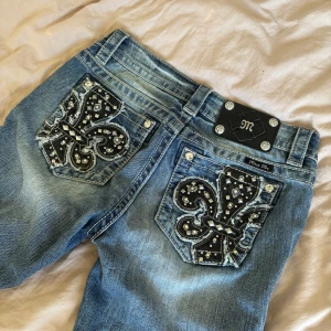  jeans från Miss Me med broderade bakfickor - Säljer ett par blå skinny jeans från Miss Me med snygga broderade detaljer och nitar på bakfickorna. Perfekta att sy om till shorts, kjol, bootcut eller varför inte bara använda som de är