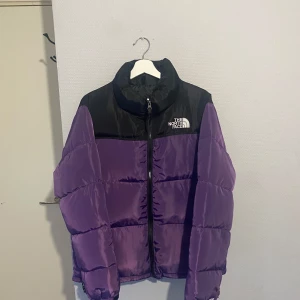 Lila The North Face  pufferjacka  - Säljer en snygg pufferjacka från The North Face i lila och svart.  Jackan är knappt använt och är i nytt skick. Inga defekter. Storlek L. Passar Som M  Kontakta för mer frågor osv