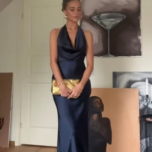 Mörkblå balklänning från Runaway The Label - Elegant mörkblå långklänning med halterneck och draperad urringning. Helt ny, lappen finns kvar. Storlek XL, men sitter som L/M