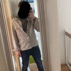 Beige overshirt från H&M - /Säljer en beige overshirt från H&M med stora bröstfickor och knäppning framtill. /Jackan är 10/10  ny utan prislapp säljer pga för stor  jackan är storlek M men passar också L