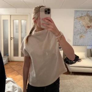 Beige stickad T-shirt - Säljer en beige stickad topp med en liten ”krage”. Mjuk och skön mot huden. Fint skick!