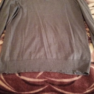 Grå stickad tröja från Livergy M/L (xl) - Mörkgrå stickad tröja från Livergy med lång ärm och ribbade muddar vid ärmslut och nederkant. Enkel och stilren modell som passar perfekt till vardags. Klassisk passform och mjukt material.