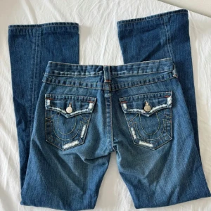 Lågmidjade bootcut/flare true religion jeans - Super esnygga true religion jeans i modellen joey, Lågmidjade och bootcut / flare!💕 Sjukt snygga och passar allt! Storlek 28 (som S)💗 är lite använda och har börjat få lite hål på sidorna av låren (men väldigt små och inte synliga)! Midja rätt över: ca 40cm. 80cm Innerbenslängd  Skriv för fler bilder / vid intresse