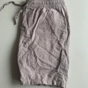 Två shorts med snörning - Beiga och turkosa  shorts med resår och snörning i midjan. Korta ben och avslappnad passform, tillverkade i ett mjukt bomullsmaterial. Perfekta för varma dagar.