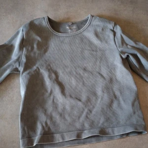 Grå ribbad långärmad tröja från H&M Move - Säljer en enkel och stilren grå ribbad långärmad tröja från H&M Move. Perfekt för en avslappnad look och passar till det mesta. Mjuk och skön med rund halsringning.