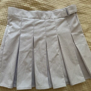 Ljuslila rutig plisserad kjol från Pull&Bear - Superfin ljuslila och vit rutig kjol från Pull&Bear med plisserad design och bred linning. Kjolen har en klassisk skoluniforms-look och stängs med knapp och dragkedja i sidan. Perfekt för dig som gillar preppy stil! Storlek L men passar M, högmidja och stretch.