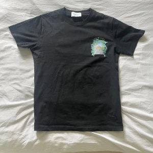 Svart t-shirt från Casablanca - Snygg svart oandvänd t-shirt från Casablanca med ett färgglatt tryck  på både fram- och baksidan. 