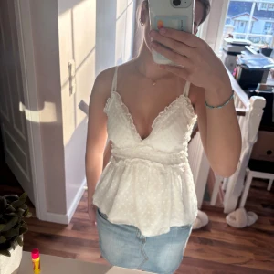 Vit top med spetsdetaljer - Säljer en söt vit linnetopp med tunna axelband och spetsdetaljer. Skriv för mer bilder vid intress💕