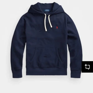 Mörkblå hoodie från Polo Ralph Lauren - Säljer en klassisk mörkblå hoodie från Polo Ralph Lauren med vit dragsko och broderad gul logga på bröstet. Tröjan har känguruficka och långa ärmar. Perfekt för en avslappnad stil. Stl s