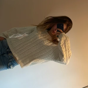 Vit stickad tröja med pärlor - Säljer en vit stickad tröja med pärldetaljer och klassiskt kabelstickat mönster. Tröjan har rund halsringning och långa ärmar. Perfekt för kyligare dagar och superenkel att styla med jeans eller kjol. Jag har köpt tröjan ungefär 2 år sedan och har knappt använt den.