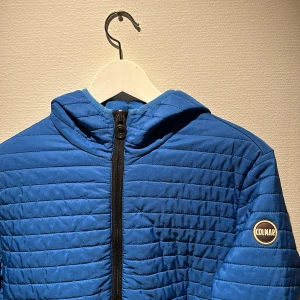 Blå pufferjacka från Colmar - Säljer en blå pufferjacka från Colmar med huva och svarta dragkedjor. Storleken på denna är Small, och skulle säga att den e tts, väldigt fint skick och nypris på en sådan här är 5000:- men säljer för betydligt bättre pris:)