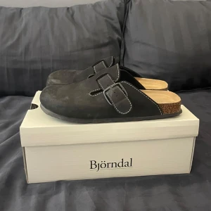 Svarta slip-in tofflor från Björndal - Säljer nu dessa skor från Björndal då dom inte kommer till användning. | Dom är snålat använda. Men som det syns på bilderna så dom lite smått damiga men det går att få bort. Så skicket är 7-8/10 skulle jag säga. | Och man får även med skoldan till skorna/tofflorna. | Det är bar att höra av sig om man har några frågor eller funderingar.