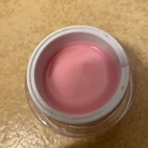 NG Thick Cover Blush UV/LED Gel - En burk med rosa gelé för naglar, NG Thick Cover Blush. Produkten är en UV/LED-gel som används som primer eller bas vid nagelförlängning eller förstärkning. Kommer i en silvrig burk med skruvlock och rymmer 30 gram.