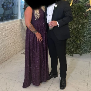 Långklänning  - Säljer en lila långklänning från Faeriesty med glittriga paljetter. Klänningen har oneshoulder-design och ett elegant fall. Perfekt för dig som vill sticka ut på festen! Klänningen är i fk men är som en L