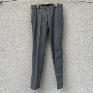 Grå kostymbyxor från Z Zegna - Snygga grå kostymbyxor från Z Zegna med klassisk rak passform. Byxorna har diskreta sidfickor, bälteshällor och stängs med dragkedja och knapp. Storlek 32.