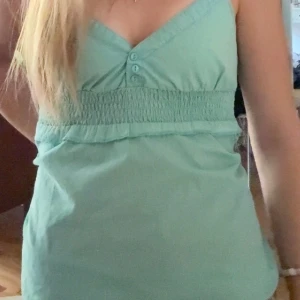 Turkis linnetopp❤️ - Säljer den snyggaste turkos linnetoppen med små knappar framtill. Perfekt till sommaren!!💗💗Säljer den för att den är lite för stor för mig. Priset diskuteras!!🥰