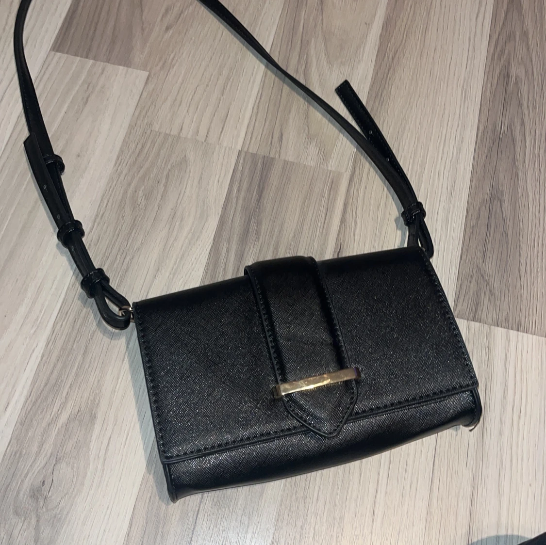 Svart axelväska med leopardmönstrat foder