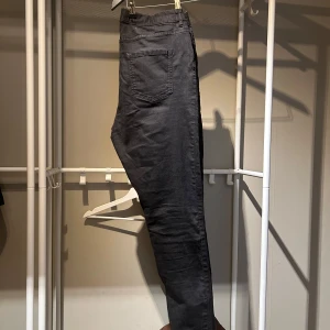 Svarta smala jeans 46/48 stretch! - Säljer ett par svart jeans från Kappahl med resår i midjan och raka ben. Byxorna har två bakfickor och är tillverkade i ett mjukt bomullsmaterial. Perfekta för en avslappnad och stilren look. Väldigt stretchiga. Har undvikit att tvätta ofta för att behålla färgen. 