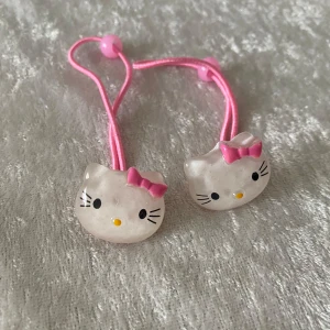 Hello Kitty hårsnoddar med rosa band - Söta hårsnoddar med Hello Kitty-motiv. Snoddarna har rosa band och dekorationer i form av genomskinliga Hello Kitty-huvuden med rosa rosetter. Perfekt för att piffa upp frisyren med en gullig detalj.  Helt ny , finns fler kvar, samma frakt 