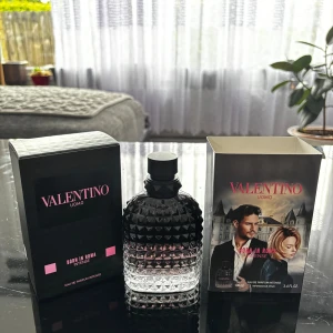 Valentino Uomo Born In Roma Intense EdP - Lyxig herrparfym från Valentino, Born In Roma Intense. Flaskan är svart med nitar och övergår till transparent nedtill. Kommer i elegant svart och rosa förpackning samt en kartong med motiv av två personer och stadsmiljö.