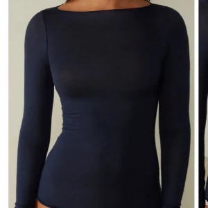 Mörkblå långärmad topp från intimissimi - Säljer en mörkblå långärmad topp med tight passform och rund halsringning. Perfekt att styla till jeans eller kjol. Enkel och stilren design som passar till många olika looks.