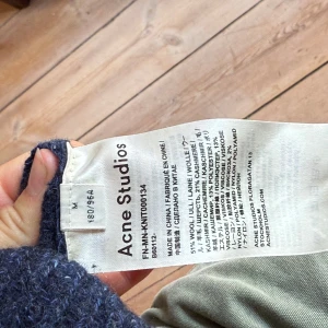 Mörkblå stickad tröja från Acne Studios - Säljer en mörkblå stickad tröja från Acne Studios i storlek M. Tröjan är gjord av ull, kashmir och polyamid, har rund halsringning och långa ärmar. Perfekt för kyligare dagar och har en klassisk, enkel design.