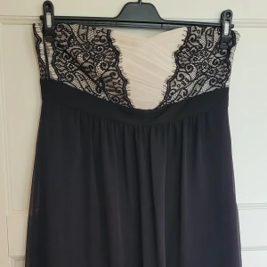 Festklänning bandeau knälång 38/M nyskick! - Esprit bandeau klänning, svart/benvit med spetsdetaljer upptill. Vackert fall i tyget! Fodrad. Knälång. Dragkedja i ena sidan. Gummerad innerkant upptill för fäste mot huden, syns på bild. Använd 2 ggr bara, välvårdad så toppenskick!  Storlekslapp o skötselråd bortklippt men är storlek 38 och kan tvättas i maskin.