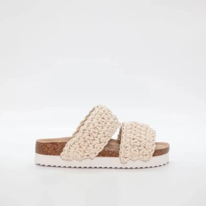Beige sandaler med stickade band - Säljer ett par snygga sandaler med två breda, stickade band i beige. Sulan är i kork-look med vit räfflad undersida för extra grepp. Perfekta för varma dagar och ger en avslappnad stil. Endast använd 2 gånger.