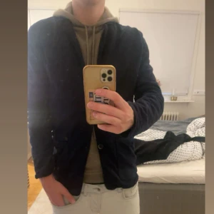 Mörkblå ”tröj” kavaj  - Säljer en stilren mörkblå ”tröj” kavaj. Klassisk design med smala slag och två framfickor. Perfekt för dig som vill ha en enkel och snygg kavaj till vardags eller mer uppklädda tillfällen. Skicket är 8/10 och storleken är M. 