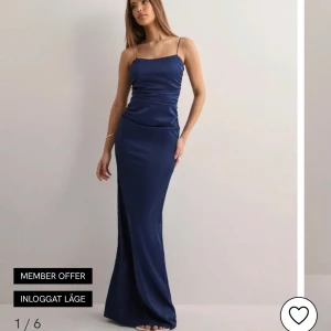 Marinblå långklänning med smala axelband - Säljer en elegant marinblå långklänning med smala axelband och figurnära passform. Klänningen har en slät satinliknande yta som ger en lyxig känsla och är perfekt för festliga tillfällen. aldirg använd, säljer då jag inte tyckte den passade mig. skriv för fler bilder😊