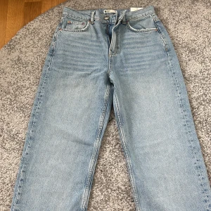 Ljusblå jeans 90s Slit från Gina Tricot - Oanvända ljusblåa jeans från Gina Tricot i modellen 90s Slit. Byxan har lappen kvar. Byxorna har raka ben med slits nertill på utsidan, klassisk femficksdesign och mid midja. Sitter perfekt på kroppen. Perfekta för en avslappnad och trendig look.❤️