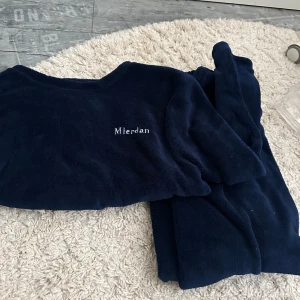 Mörkblå mjukisbyxor från Mierdan - Mysiga mörkblå mjukisbyxor från Mierdan i supermjuk fleece. Perfekta för hemmakvällar eller när du vill vara extra bekväm. Matchande tröja finns också om du vill ha ett set. Passar S och Xs