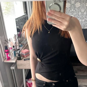 svart topp med guld detalj  - svart topp med en guld detalj! super skönt material Storlek S och är i nytt skick🤍vid intresse kan jag fixa ” köp nu”