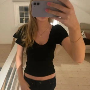 Svart tight topp med v-ringning - En svart, tight topp med korta ärmar och djup v-ringning. Har för mig att den är från Vila! Lånade bilder💓