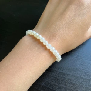Pärlarmband i vitt🤍 - Säljer ett stilrent armband med vita pärlor. Armbandet har en klassisk design med runda pärlor som sitter på en elastisk tråd, vilket gör det enkelt att ta på och av. Perfekt för att ge en elegant touch till din outfit.🤍