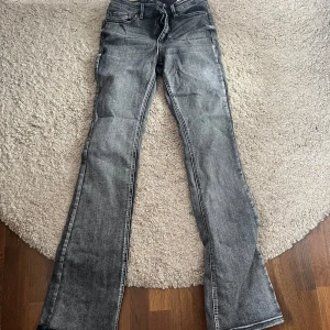 Grå bootcut jeans från Vero Moda - Snygga grå jeans från Vero Moda med bootcut-passform. Jeansen har klassisk femficksdesign, dragkedja och knapp i midjan. Perfekta för dig som vill ha en tidlös look med lite utsvängda ben. Använda fåtal gånger. Mid waist. 