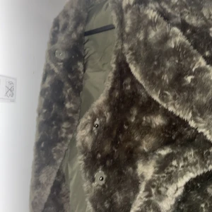 Grön  pälsjacka från Saint Tropez - Säljer en fluffig och snygg brun pälsjacka från Saint Tropez. Jackan har en oversized look, stora knappar framtill och är helfodrad med mjukt tyg på insidan. Perfekt för dig som vill ha en varm och trendig jacka med statement-känsla.